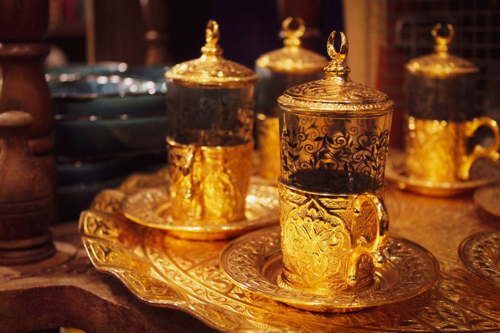Home Luxurious gold tea set with intricate designs on a decorative tray, Doha.