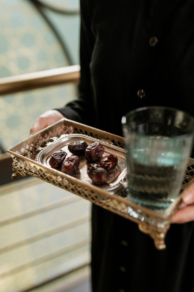 Home Close-up of dates and water on an elegant metallic tray indoors. Perfect for dining themes.