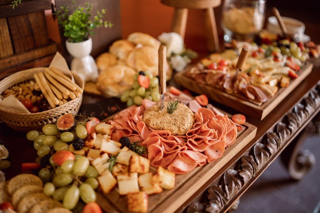 Home Delightful charcuterie board with meats, cheeses, and fresh fruits at an event setup.
