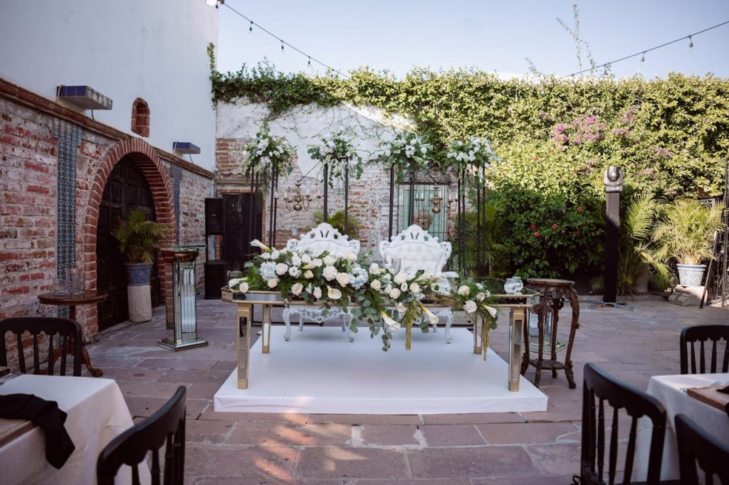 Home Beautiful wedding setup with elegant floral arrangements and seating in an outdoor courtyard.